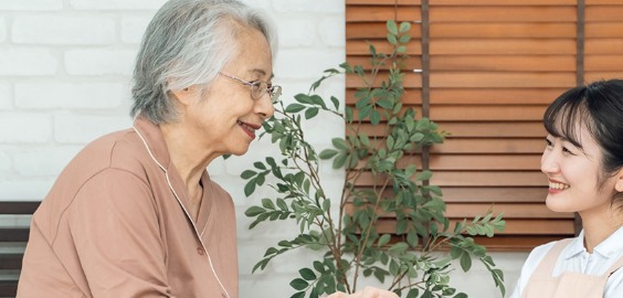 ご自宅で、看護師が利用者様と笑顔で向き合っている様子